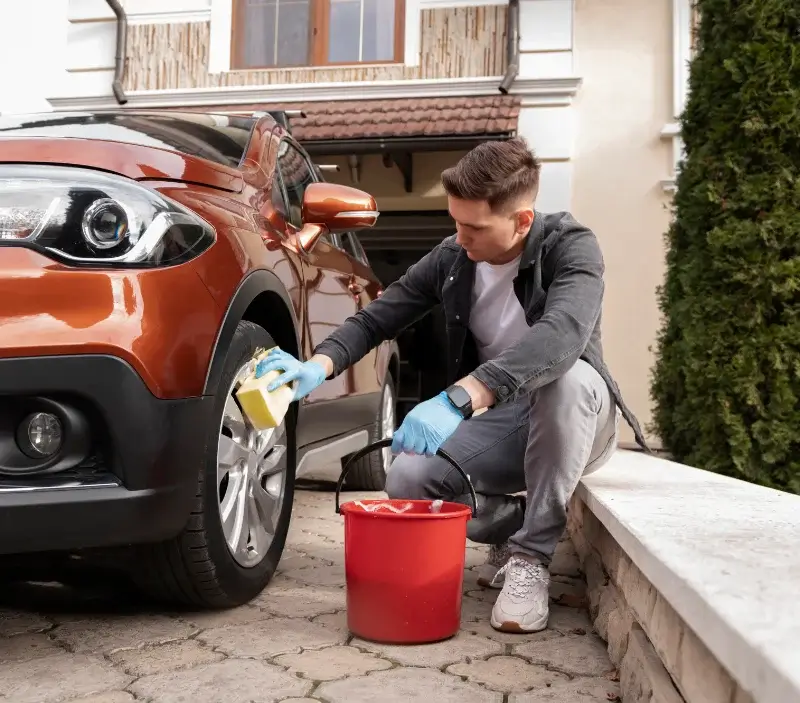 Lavage auto à domicile Lully : professionnel intervenant sur un véhicule